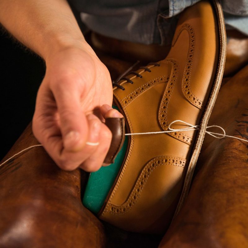 Shoemaker in workshop making shoes.